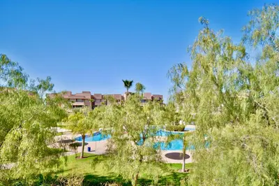 a resort with a swimming pool and trees at Appartement, Prestigia Marrakech in Marrakech