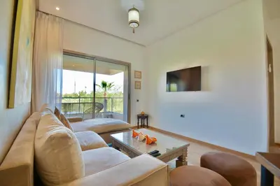 a living room with a couch and a tv at Appartement, Prestigia Marrakech in Marrakech