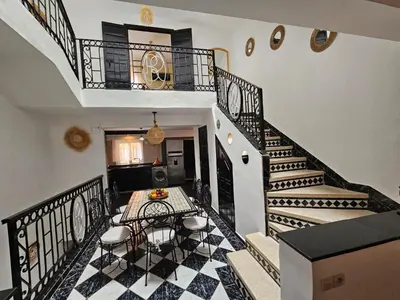 a room with a staircase with a table and chairs at Riad Latifa in Marrakech