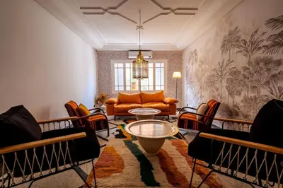 a living room with a couch and a table and chairs at Cosy Appartement 5min de Majorelle in Marrakech