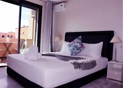 a bedroom with a white bed with a large window at Central Marrakech Stay Bright & Airy with Scenic Gueliz location in Marrakech