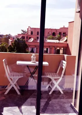 a table and two chairs on a balcony at Central Marrakech Stay Bright & Airy with Scenic Gueliz location in Marrakech