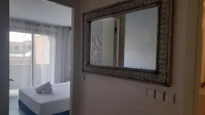 a mirror on a wall with a bed and a window at Central Marrakech Stay Bright & Airy with Scenic Gueliz location in Marrakech