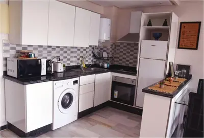 a kitchen with white cabinets and a washer and dryer at Central Marrakech Stay Bright & Airy with Scenic Gueliz location in Marrakech