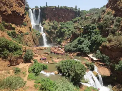 a waterfall in the middle of a canyon with trees at Chic Hideaway - Marrakech Centre in Marrakech
