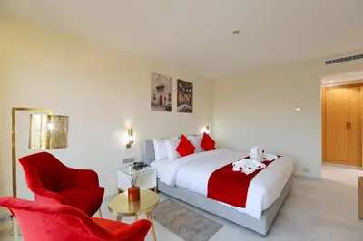 a bedroom with a bed and a red chair at Ari Boutique Hôtel - Adult Only in Marrakech