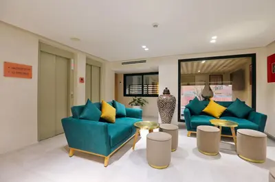 a lobby with two blue chairs and a table at Ari Boutique Hôtel - Adult Only in Marrakech