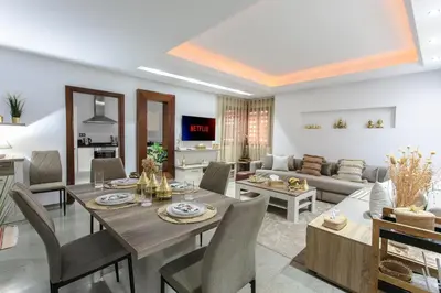 a dining room and living room with a table and chairs at Elite Escape - Marrakech Centre in Marrakech