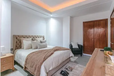 a bedroom with a large bed and a chair at Elite Escape - Marrakech Centre in Marrakech