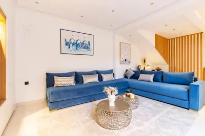 a blue couch in a living room with a table at Loft Duplex Familial 200m2 Neuf - Centre Gueliz in Marrakech