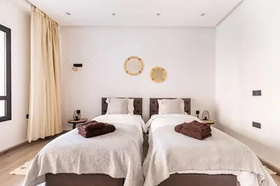 two beds in a room with white walls at Loft Duplex Familial 200m2 Neuf - Centre Gueliz in Marrakech