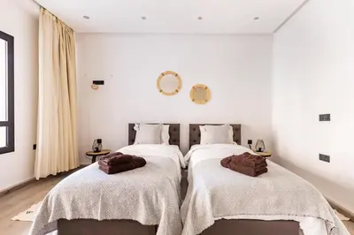 two beds in a room with white walls at Loft Duplex Familial 200m2 Neuf - Centre Gueliz in Marrakech