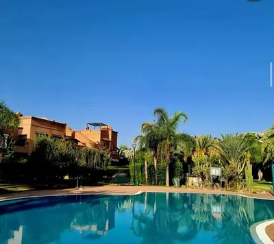 a large swimming pool with palm trees and buildings at Atlas golf resort in Marrakech